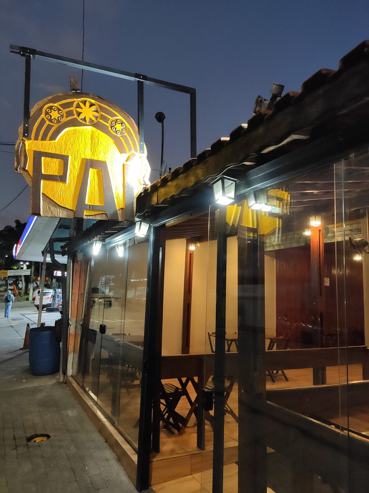 Fachada do Ó Paí Culinária à noite, com o luminoso aceso