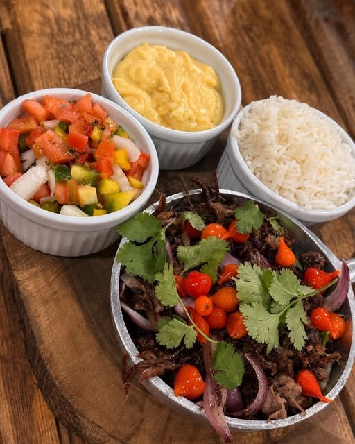 Prato com carne desfiada, vinagrete, arroz e purê